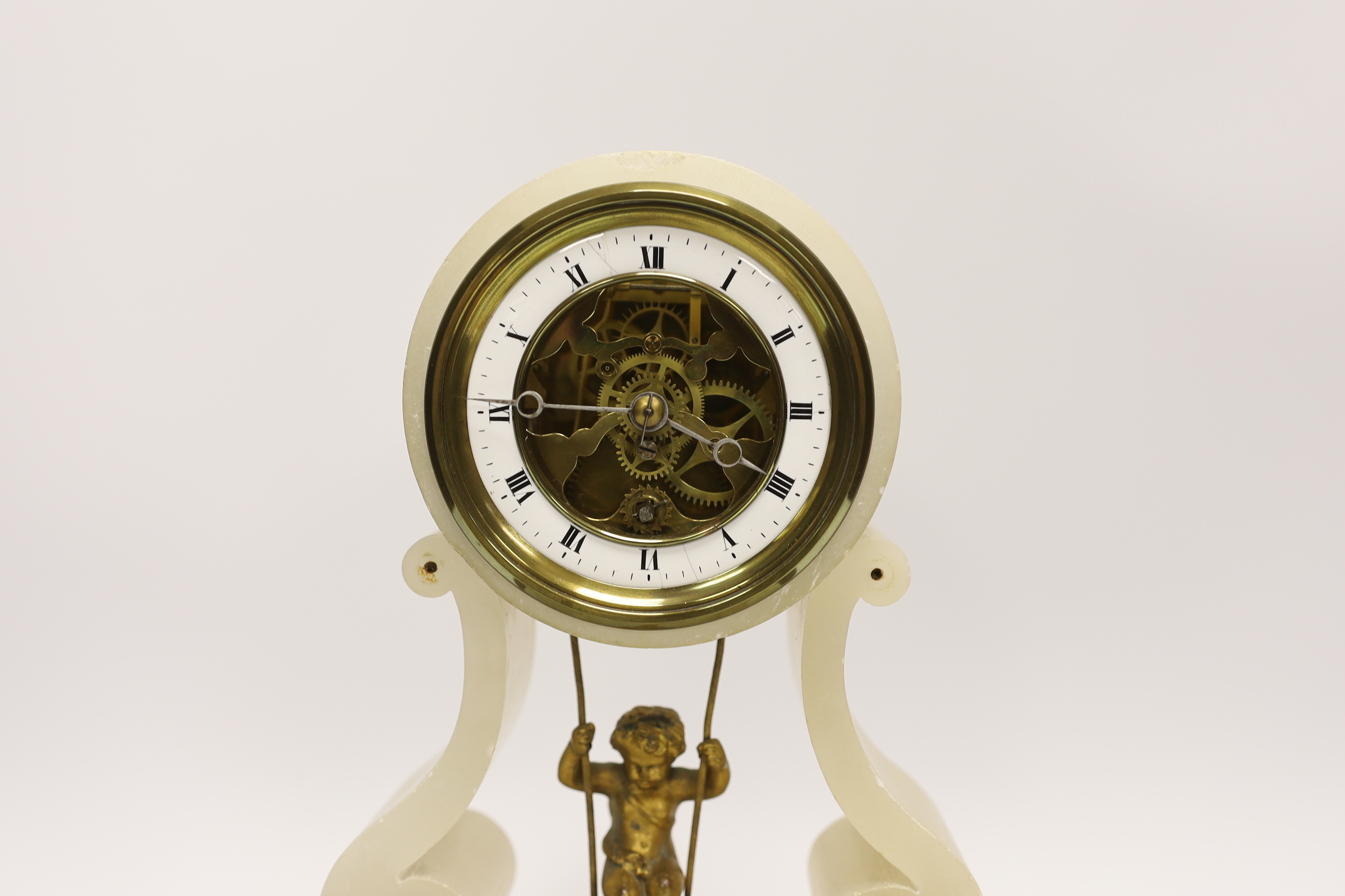 An alabaster French mantel timepiece with ‘swinging cherub’ pendulum and key, under a dome, 33cm